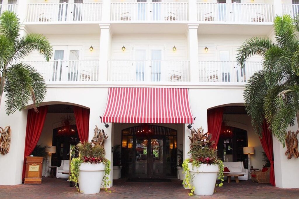 entrance to bohemian hotel in celebration florida with white walls and red awning